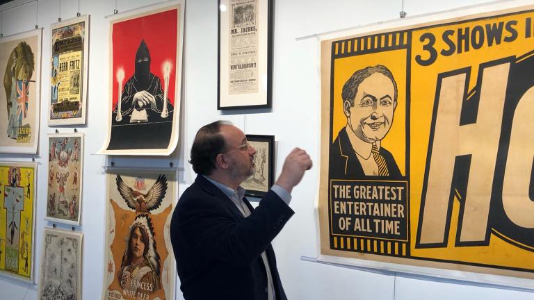 Gabe Fajuri of Potter & Potter Auctions looks over a collection of posters from magician Ricky Jay set to be auctioned off. (Marc Vitali / WTTW News)