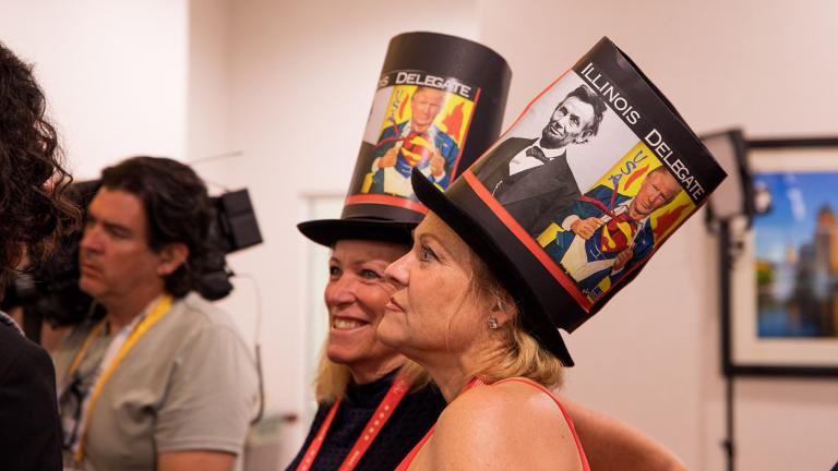 Susan Sweeney, an Illinois delegate of the 9th Congressional District, (left) and Robin Hans, alternate Illinois delegate, wearing Abraham Lincoln-inspired top hats while picking up their credentials at the Illinois Delegates Breakfast on Monday, July 15, 2024. (Michael Izquierdo / WTTW News)  