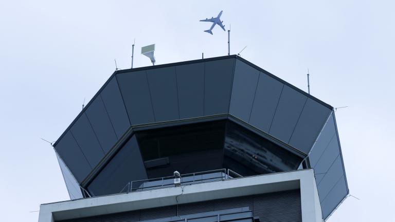 In this Monday, April 22, 2019 file photo, a plane flies over the south air traffic control tower at O'Hare International Airport in Chicago. (AP Photo / Kiichiro Sato, File)