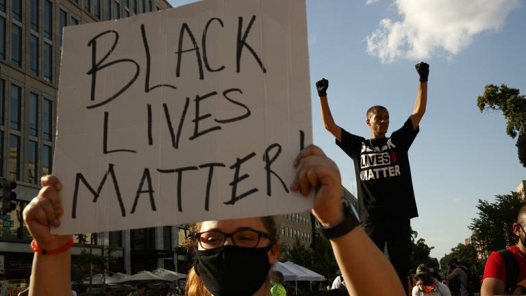 In this June 24, 2020, file photo, Antonio Mingo, right, holds his fists in the air as demonstrators protest in front of a police line on a section of 16th Street that’s been renamed Black Lives Matter Plaza, in Washington. (AP Photo / Jacquelyn Martin, File)