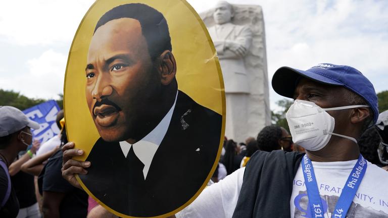 A man holds a photo of Martin Luther King, Jr., at the Martin Luther King Jr. Memorial during the March on Washington, Friday Aug. 28, 2020, in Washington. (AP Photo / Carolyn Kaster)