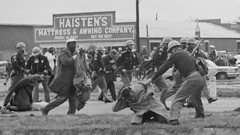 In this March 7, 1965, file photo, a state trooper swings a billy club at John Lewis, right foreground, chairman of the Student Nonviolent Coordinating Committee, to break up a civil rights voting march in Selma, Ala. (AP Photo / File)