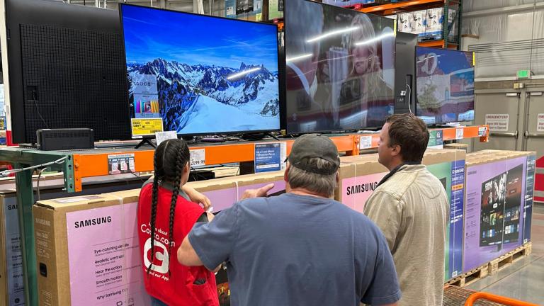 Shoppers consider a large-screen television with the help of a sales associate in a Costco warehouse Thursday, May 1, 2025, in Sheridan, Colo. (AP Photo / David Zalubowski)
