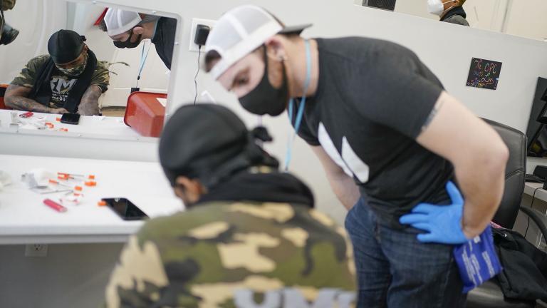 Brian Hackel, right, an overdose prevention specialist, helps Steven Baez, a client suffering addiction, find a vein to inject intravenous drugs at an overdose prevention center, at OnPoint NYC in New York, N.Y., Friday, Feb. 18, 2022. (AP Photo / Seth Wenig)