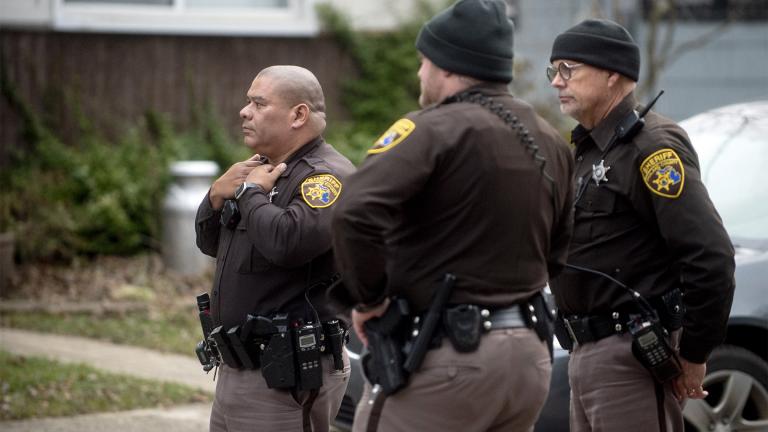 Three Oakland County Sheriff's deputies survey the grounds outside of the Crumbley residence while seeking James and Jennifer Crumbley, parents of alleged Oxford High School shooter Ethan Crumbley, on Friday, Dec. 3, 2021, in Oxford, Mich. (Jake May / The Flint Journal via AP)
