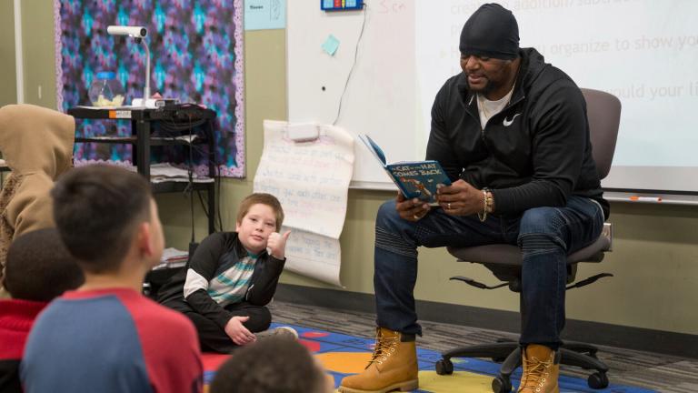 In this image provided by the Des Moines Public Schools, Will Keeps reads a Dr. Seuss story to students at Lovejoy Elementary School in Des Moines, Iowa, during their “VIPs Read to Students” event on March 2, 2020. (Kyle Knicley / Des Moines Public Schools via AP)