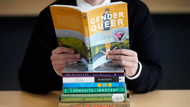 Amanda Darrow, director of youth, family and education programs at the Utah Pride Center, poses with books that have been the subject of complaints from parents in Salt Lake City on Dec. 16, 2021. (AP Photo / Rick Bowmer, File)
