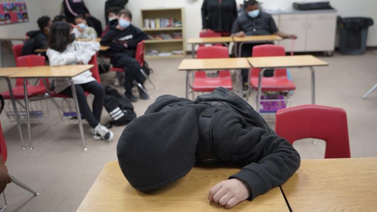 An unidentified student rests on his desk as the Mojave Unified School District Superintendent Katherine Aguirre, center rear, addresses students before their spring break at California City Middle School in California City, Calif., on Friday, March 11, 2022. (AP Photo/Damian Dovarganes)