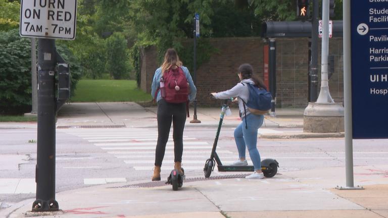 In this file photo, riders use electric scooters on the campus of the University of Illinois at Chicago. The city started its four-month scooter pilot program in June 2019. (WTTW News)