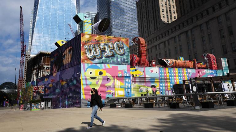 A woman walks by the colorful murals that surround the foundation for 2 World Trade Center, Wednesday, Sept. 8, 2021 in New York. (AP Photo / Mark Lennihan)