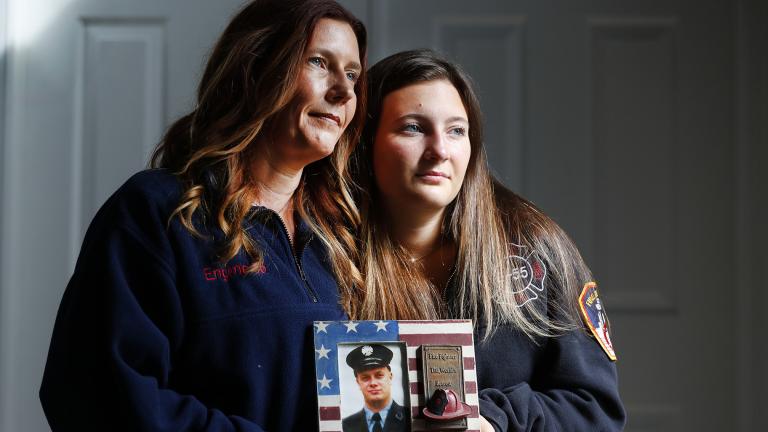 Pamela Yarosz and her daughter Capri are shown with a photo of New York firefighter Christopher Michael Mozzillo Saturday, Sept. 7, 2024, in Freehold, N.J.. Mozzillo, who died in the 9/11 attacks, was Pamela's brother. (AP Photo / Noah K. Murray)