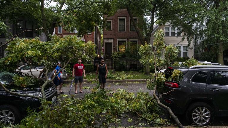 A group of neighbors surveys the damage to vehicles on their block after a severe thunderstorm battered Chicago neighborhoods, Monday, Aug. 10, 2020. (Tyler LaRiviere / Sun-Times / Chicago Sun-Times via AP)