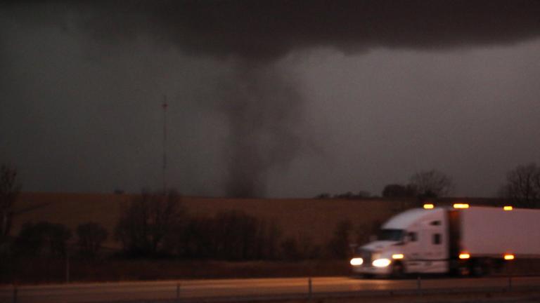 A tornado approaches Interstate 80 near Atlantic, Iowa, as a semi truck rolls eastward on Wednesday, Dec. 15, 2021. (Bryon Houlgrave/The Des Moines Register via AP)