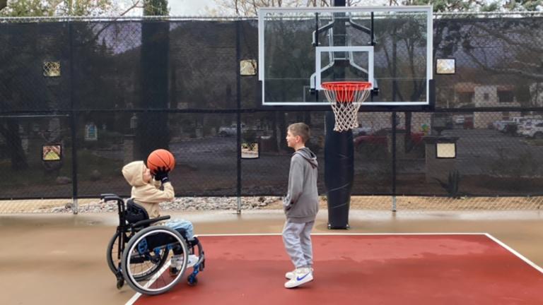 This undated photo provided by Jasculca Terman Strategic Communications shows twin brothers Cooper and Luke Roberts playing basketball. Cooper was a victim of the 2022 Fourth of July parade shooting in Highland Park, Ill., and remains paralyzed from the waist down. (The Roberts Family / Jasculca Terman Strategic Communications via AP)