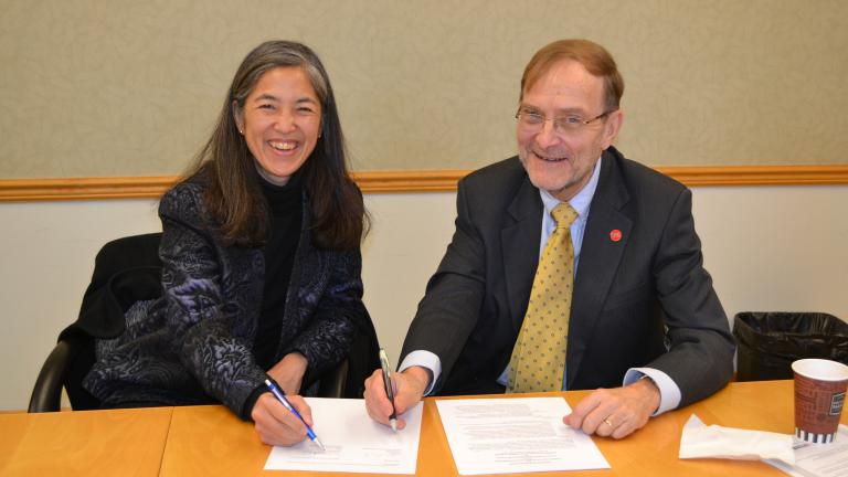 Chicago Department of Public Health commissioner Dr. Julie Morita and UIC School of Public Health Dean Dr. Paul Brandt-Rauf sign an agreement formalizing the yearslong partnership between the two organizations. (UIC School of Public Health)
