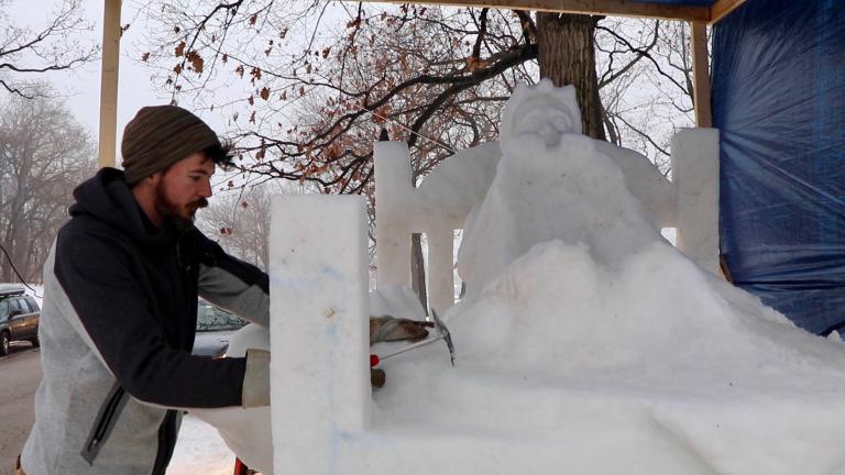 Snow sculptor George Burnette works on his sculpture “Don't Look Under the Bed” on Friday during the Illinois Snow Sculpting Competition in Rockford, Illinois. (Evan Garcia / WTTW)