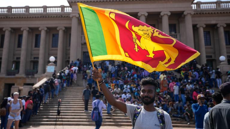 A protester waves a national flag outside president Gotabaya Rajapaksa’s office in Colombo, Sri Lanka, Wednesday, July 13, 2022. (AP Photo / Eranga Jayawardena)