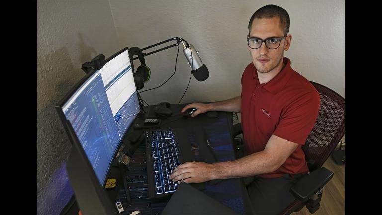 In this Sept. 20, 2021, photo Austin Moody poses for a photo as he sits a his home work station in Tampa, Fla. (AP Photo / Steve Nesius)