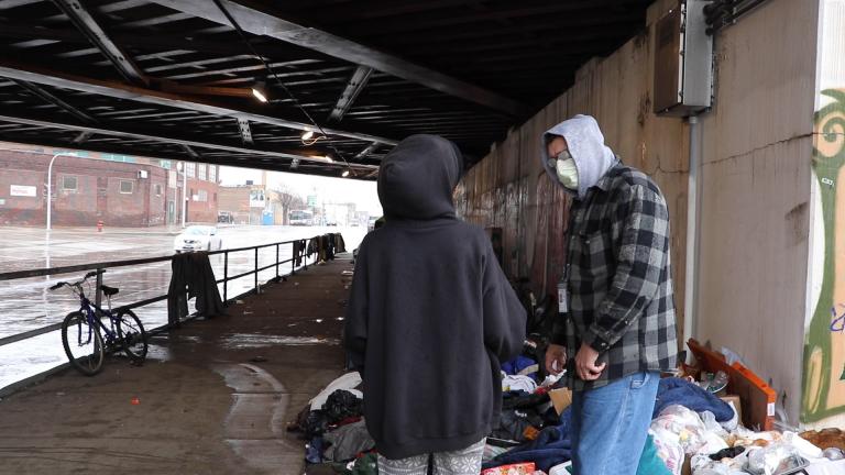 Stephan Koruba, a nurse practitioner with nonprofit The Night Ministry, speaks to a woman at a homeless encampment on Chicago’s West Side. (Evan Garcia / WTTW News) Stephan Koruba, a nurse practitioner with nonprofit The Night Ministry, speaks to a woman at a homeless encampment on Chicago’s West Side. (Evan Garcia / WTTW News)