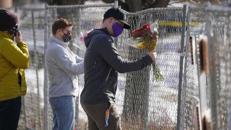 Kiefer Johnson places a bouquet of flowers into a makeshift fence put up around the parking lot outside a King Soopers grocery store where a mass shooting took place a day earlier, in Boulder, Colo., Tuesday, March 23, 2021. (AP Photo / David Zalubowski) Kiefer Johnson places a bouquet of flowers into a makeshift fence put up around the parking lot outside a King Soopers grocery store where a mass shooting took place a day earlier, in Boulder, Colo., Tuesday, March 23, 2021. (AP Photo / David Zalubowski)