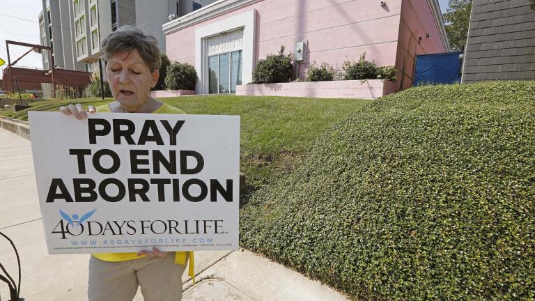 In this Oct. 2, 2019. file photo, an abortion opponent sings to herself outside the Jackson Womens Health Organization clinic in Jackson, Miss. (AP Photo / Rogelio V. Solis, File)