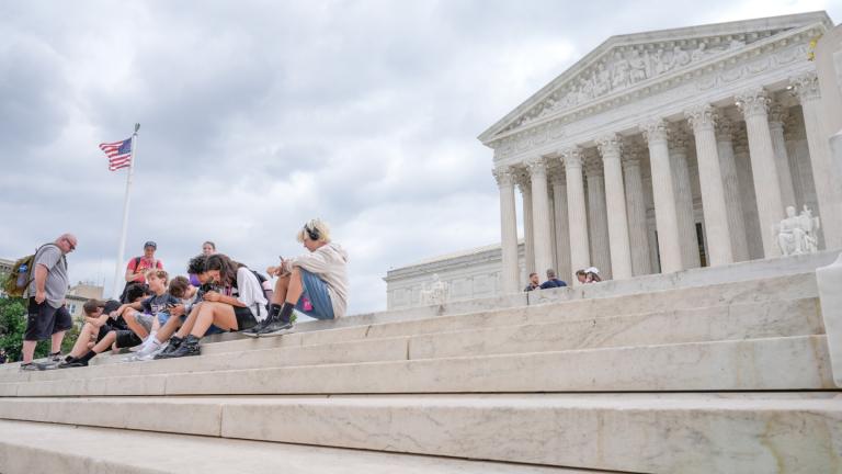 Visitors sit on the steps of the U.S. Supreme Court, Monday, June 8, 2026, in Washington. (AP Photo / Mariam Zuhaib)