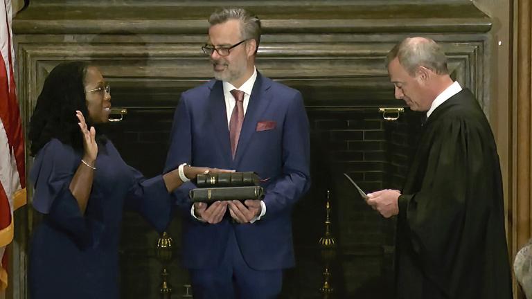 In this image from video provided by the Supreme Court, Chief Justice of the United States John Roberts administers the Constitutional Oath to Ketanji Brown Jackson as her husband Patrick Jackson holds the Bible at the Supreme Court in Washington, Thursday, June 30, 2022. (Supreme Court via AP)