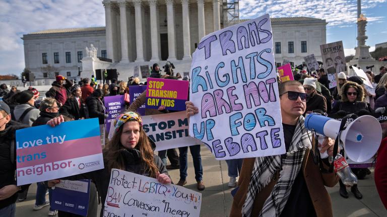 Supporters of transgender rights Sarah Kolick, left, of Cleveland, and Derek Torstenson, of Colorado Springs, Colo., right, rally by the Supreme Court, Wednesday, Dec. 4, 2024, in Washington, while arguments are underway in a case regarding a Tennessee law banning gender-affirming medical care for transgender youth. Behind the two are people who support the ban. (Jacquelyn Martin / AP Photo)