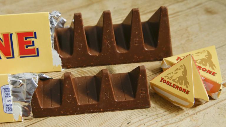 Two bars of the Toblerone Swiss chocolate are shown, at front is the new style 150 gram bar showing the reduction in triangular pieces, in the background is the older style 360 gram bar, pictured in London, on Nov. 8, 2016. (AP Photo/Alastair Grant, File)