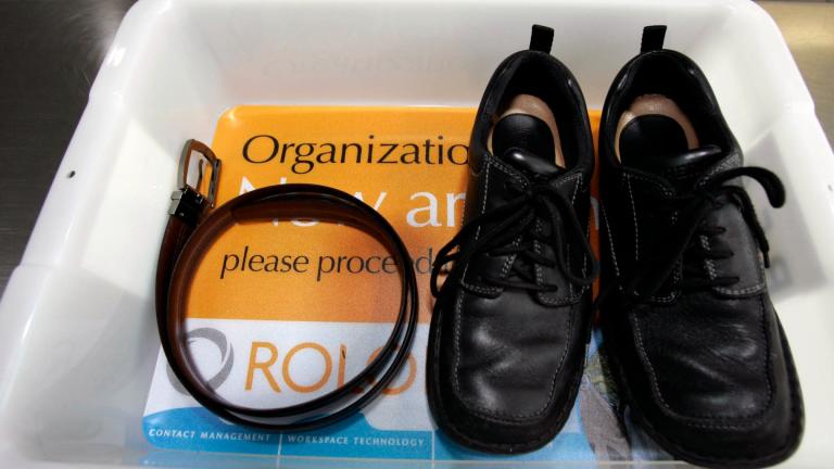 In this Jan. 10, 2007, file photo, a belt and shoes sit in a trays with advertising that is being used in the safety screening of travelers done by the Transportation Security Administration, at the Los Angeles International Airport in Los Angeles. (AP Photo / Ann Johansson, File)