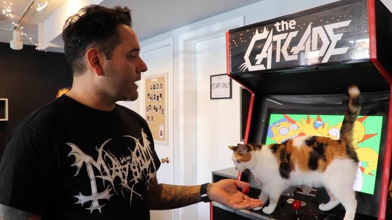 Catcade co-founder Chris Gutierrez shows off one of the rescue shelter’s free arcade games. (Evan Garcia / WTTW News)