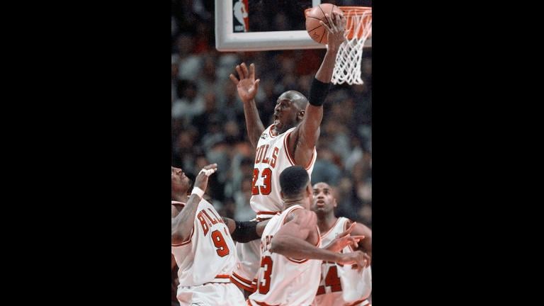 In this June 10, 1998, file photo, Chicago Bulls’ Michael Jordan reaches high above teammates Dennis Rodman, left, Scottie Pippen, and Scott Burrell (24) for a rebound against the Utah Jazz in the second half of Game 4 in the NBA Finals in Chicago. (AP Photo / Michael S. Green, File)