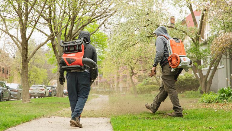 Landscapers from Touch of Life Lawn Care work on an Evanston lawn with electric leaf blowers on April 23, 2024. (Michael Izquierdo / WTTW News)