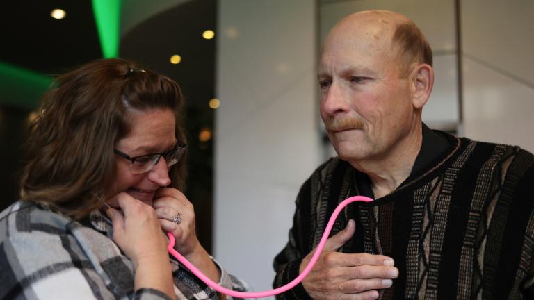 Amber Morgan, from South Bend, Ind., listens to the heartbeat of Tom Johnson, from Kankakee, at Travelodge by Wyndham Downtown Chicago, on Saturday, Nov. 19, 2022, in Chicago. (Michael Blackshire / Chicago Tribune via AP)