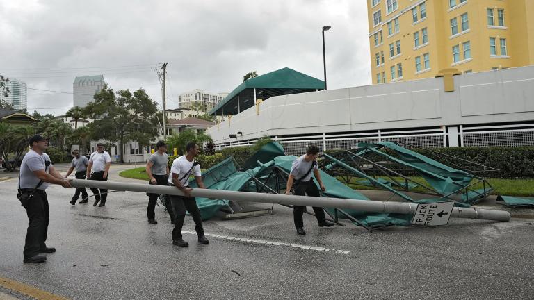 Members of the Tampa Fire Rescue Dept., remove a street pole after large awnings from an apartment building blew off from winds associated with Hurricane Idalia Wednesday, Aug. 30, 2023, in Tampa, Fla. Idalia made landfall earlier this morning along the Big Bend of the state. (AP Photo / Chris O’Meara)