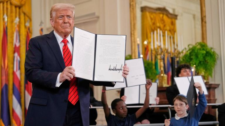 President Donald Trump, left, holds up a signed executive order as young people hold up copies of the executive order they signed at an education event in the East Room of the White House in Washington, Thursday, March 20, 2025. (AP Photo / Ben Curtis)