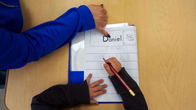 FILE - Easterseals Head Start program teaching assistant Tania Ortiz helps a student practice writing his name, Jan. 29, 2025, in Miami. (AP Photo / Rebecca Blackwell, File)
