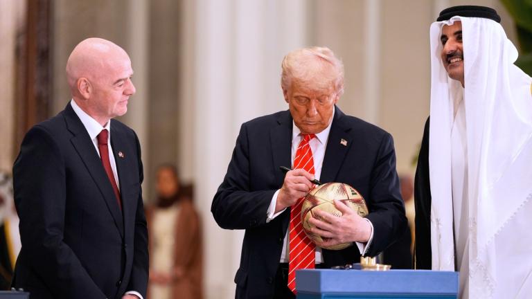 President Donald Trump signs a FIFA soccer ball as Qatar's Emir Sheikh Tamim bin Hamad Al Thani and FIFA President Gianni Infantino looks on at the Lusail Palace, Wednesday, May 14, 2025, in Doha, Qatar, as they marked the passing of World Cup hosting duties from Qatar, which held it in 2022, to the United States, which is hosting in 2026. (AP Photo / Alex Brandon)