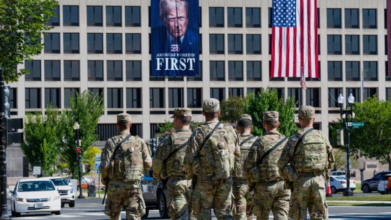 Armed National Guard soldiers from West Virginia patrol the Mall near the Labor Department in Washington, where a poster of President Donald Trump is displayed, Aug. 26, 2025. (AP Photo / J. Scott Applewhite, File)