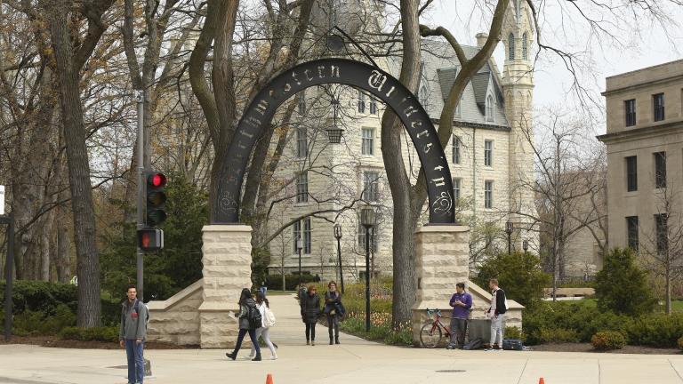 People stand near the entrance gate to Northwestern University in Evanston, Ill., April 29, 2016. (Chris Walker/Chicago Tribune via AP)/Chicago Tribune via AP)