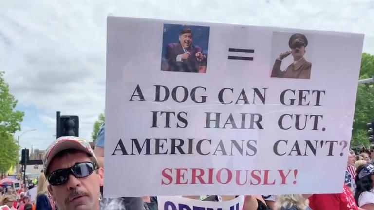 A tweet from reporter Mike Miletich shows video of a man carrying a sign at a protest on Saturday, May 16, in Springfield, Illinois. (@MikeMiletichTV / Twitter) 