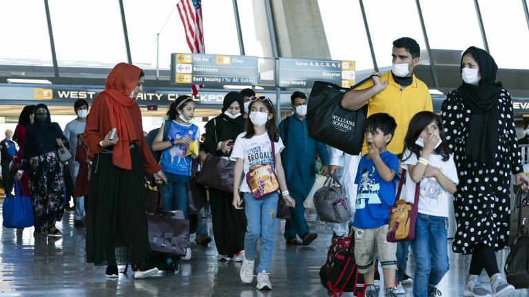 Families evacuated from Kabul, Afghanistan, walk through the terminal before boarding a bus after they arrived at Washington Dulles International Airport, in Chantilly, Va., on Thursday, Sept. 2, 2021. (AP Photo / Jose Luis Magana)