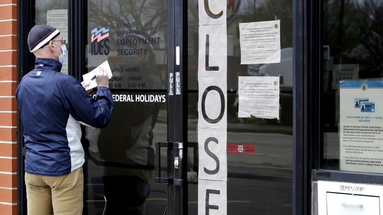In this April 30, 2020 file photo, a man writes information in front of Illinois Department of Employment Security in Chicago. (AP Photo / Nam Y. Huh, File)