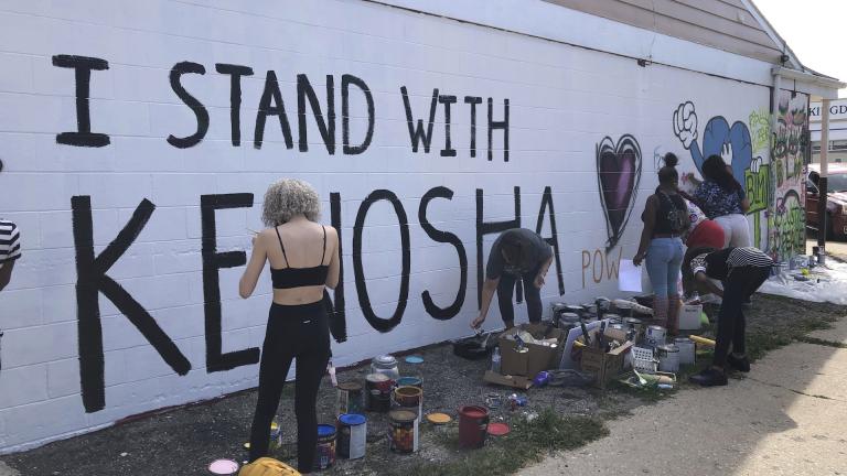 Volunteers paint murals on boarded-up businesses in Kenosha, Wis., on Sunday, Aug. 30, 2020, at an "Uptown Revival." (AP Photo/ Russell Contreras)