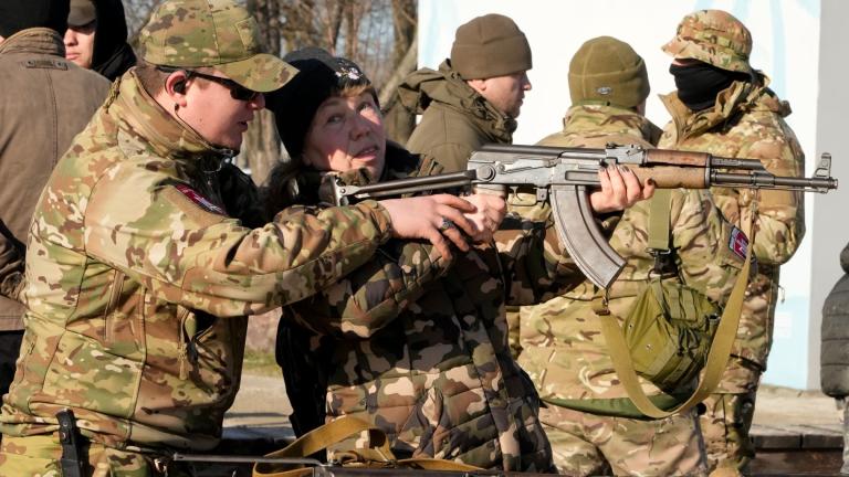 An instructor shows a woman how to use a Kalashnikov assault rifle, as members of a Ukrainian far-right group train, in Kyiv, Ukraine, Sunday, Feb. 13, 2022. (AP Photo / Efrem Lukatsky)