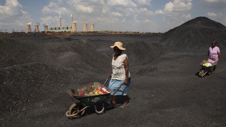 Women push wheelbarrows atop a coal mine dump at the coal-powered Duvha power station, near Emalahleni east of Johannesburg, Nov. 17, 2022. (AP Photo/Denis Farrell, File)