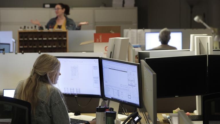 Architectural designer Erica Shannon, front, works at a computer as accounting manager Andrea Clark, top, speaks with a colleague at the design firm Bergmeyer, Wednesday, July 29, 2020, at the company’s offices, in Boston. (AP Photo / Steven Senne) Architectural designer Erica Shannon, front, works at a computer as accounting manager Andrea Clark, top, speaks with a colleague at the design firm Bergmeyer, Wednesday, July 29, 2020, at the company’s offices, in Boston. (AP Photo / Steven Senne)