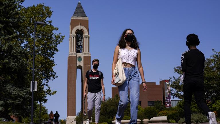 Masked students walk through the campus of Ball State University in Muncie, Ind., Thursday, Sept. 10, 2020. College towns across the U.S. have emerged as coronavirus hot spots in recent weeks as schools struggle to contain the virus. (AP Photo/Michael Conroy)