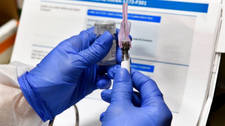 In this July 27, 2020, file photo, nurse Kathe Olmstead prepares a shot that is part of a possible COVID-19 vaccine, developed by the National Institutes of Health and Moderna Inc., in Binghamton, N.Y. (AP Photo / Hans Pennink, File)