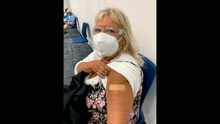 In this photo provided by Terry Beth Hadler , the 69-year-old, poses after receiving a dose of a COVID-19 vaccine on Tuesday, Dec. 29, 2020, at a Bonita Springs, Fla. Library. (Courtesy of Terry Beth Hadler via AP)